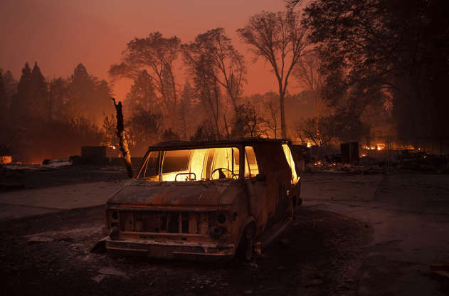 Slide 1 of 50: Flames burn inside a van as the Camp Fire tears through Paradise, Calif., on Thursday, Nov. 8, 2018. Tens of thousands of people fled a fast-moving wildfire Thursday in Northern California, some clutching babies and pets as they abandoned vehicles and struck out on foot ahead of the flames that forced the evacuation of an entire town and destroyed hundreds of structures. (AP Photo/Noah Berger)