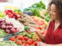 a woman standing in front of a fruit: Organic Foods That Aren’t Worth Organic Prices