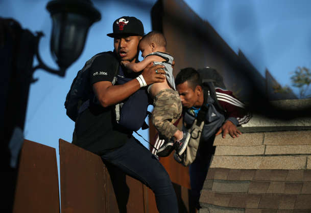 Slide 2 of 50: Migrants, part of a caravan of thousands from Central America trying to reach the United States, prepare to climb over the border wall into the U.S. from Tijuana, Mexico, December 13, 2018. REUTERS/Leah Millis - RC15B83E0970