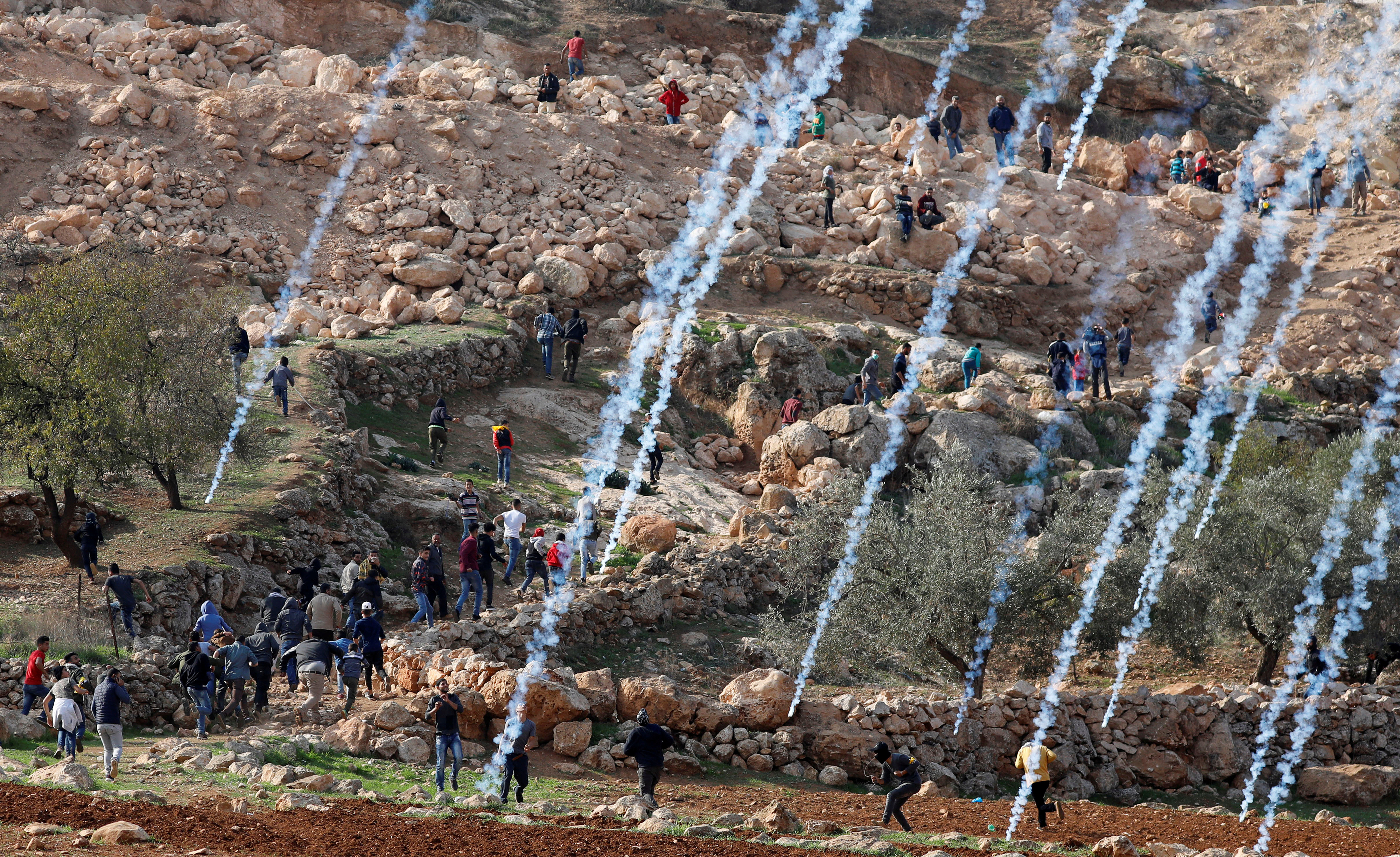Slide 4 of 36: Tear gas canisters are fired by Israeli troops towards Palestinians during a protest against Israeli land seizures for Jewish settlements, near Ramallah in the occupied West Bank November 30, 2018.