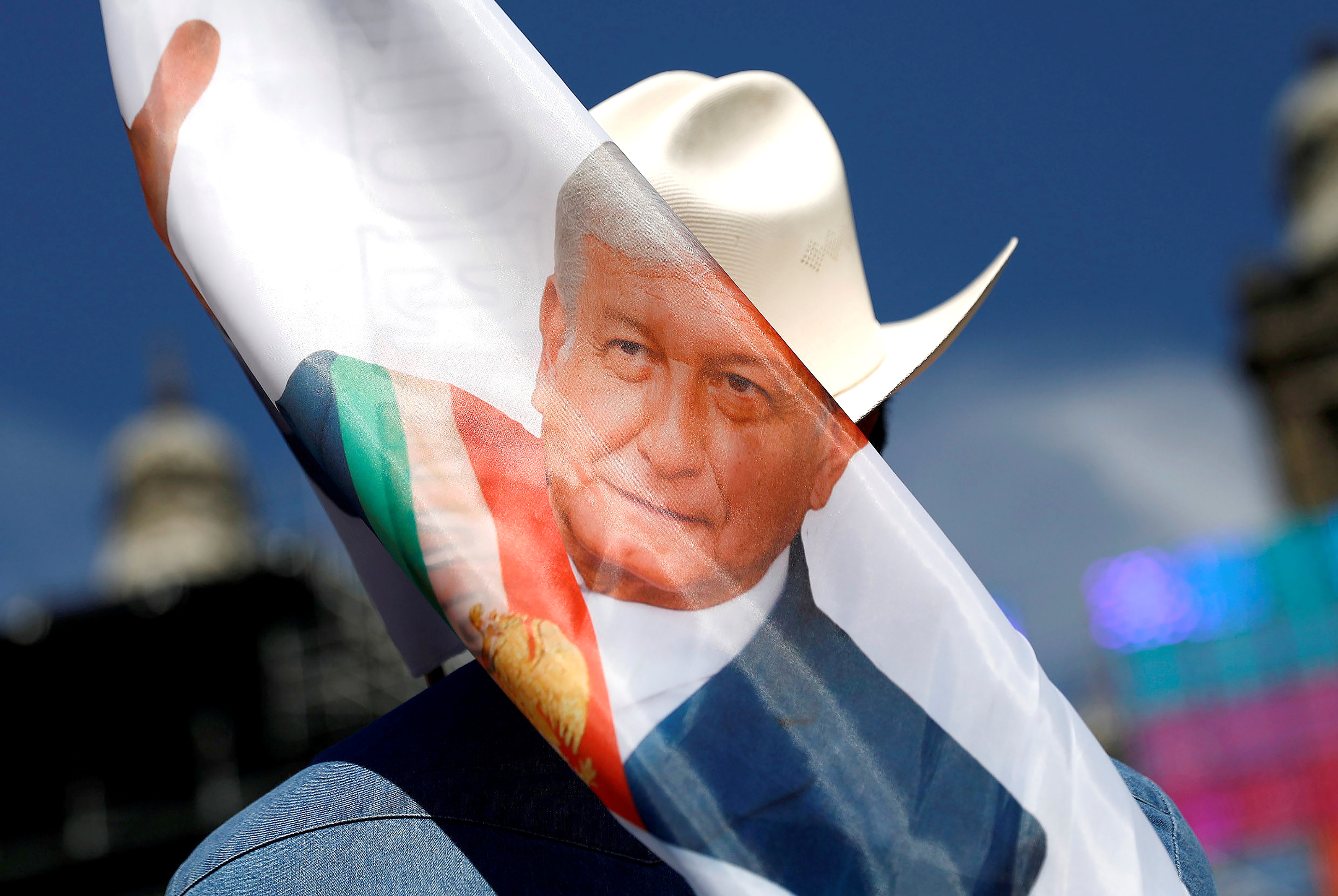 Slide 9 of 36: Andres Manuel Lopez Obrador holds a banner while waiting for his arrival at Zocalo square in Mexico City, Mexico December 1, 2018.
