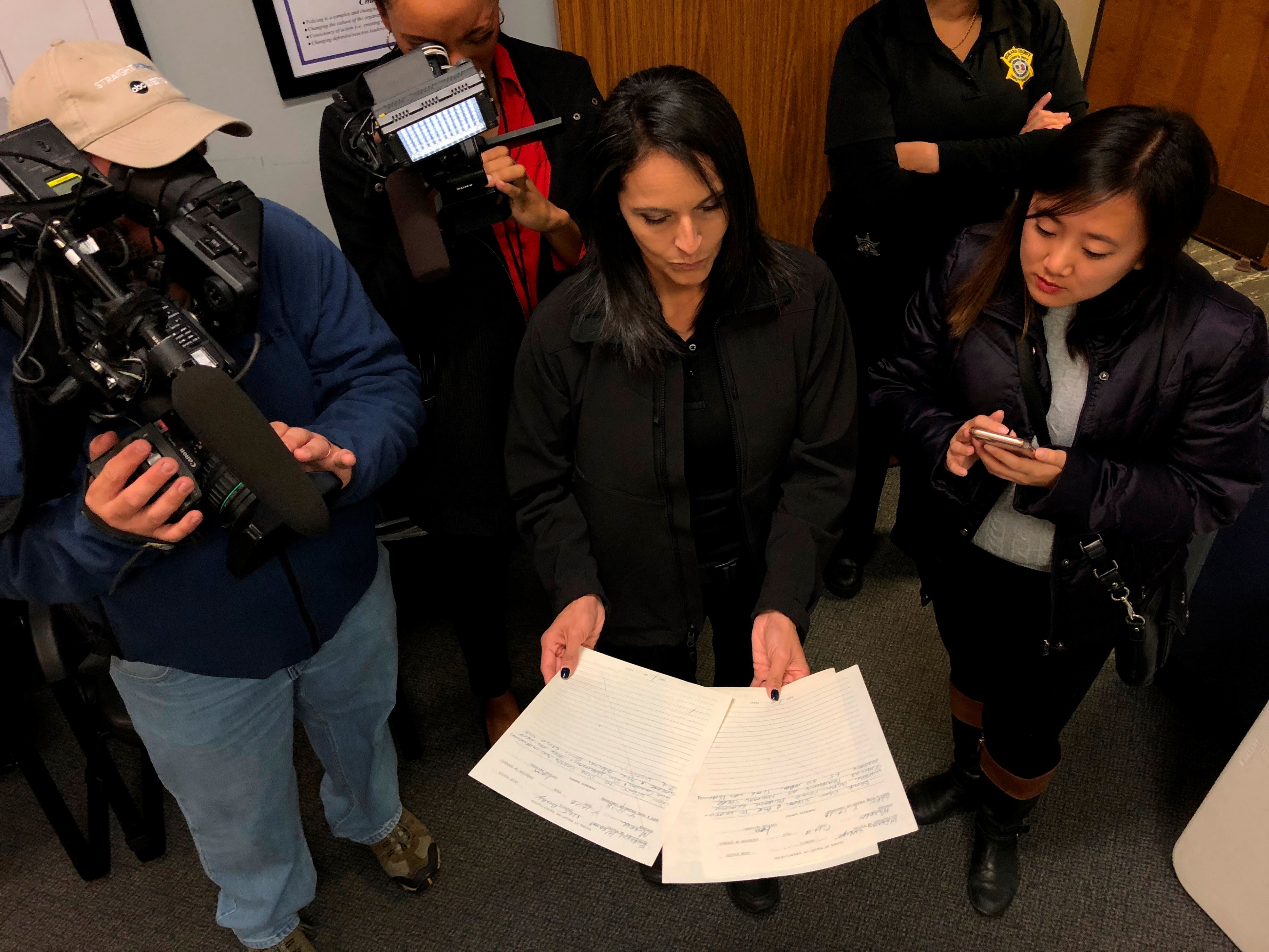 Richland County Sheriff's Capt. Maria Yturria holds up Sheriff Leon Lott's handwritten notes from the 1978 killing of Evelyn Weston on Wednesday, Nov. 21, 2018, in Columbia, S. C. Weston was likely killed by Samuel Little, who investigators say has confessed to as many as 90 killings across the United States. Lott was a rookie investigator assigned Weston's death and said he never forgot the case.  (AP Photo/Jeffrey Collins)