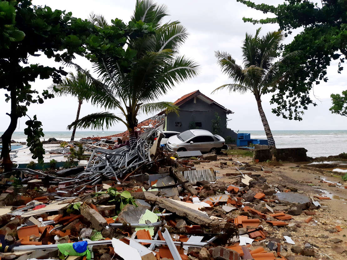 Slide 1 of 43: A car is seen among ruins after a tsunami hit Carita beach in Pandeglang, Banten province, Indonesia, December 23, 2018.