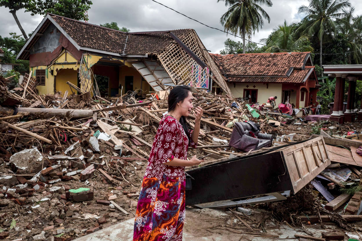 Slide 2 of 43: A woman reacts as she looking for their belonging at a destroyed houses after hit by tsunami on December 24, 2018 in Carita, Banten province,  Indonesia. Over 280 people have reportedly been killed after a volcano-triggered tsunami hit the coast around Indonesia's Sunda Strait on Saturday night, injuring at least 1,016 people.