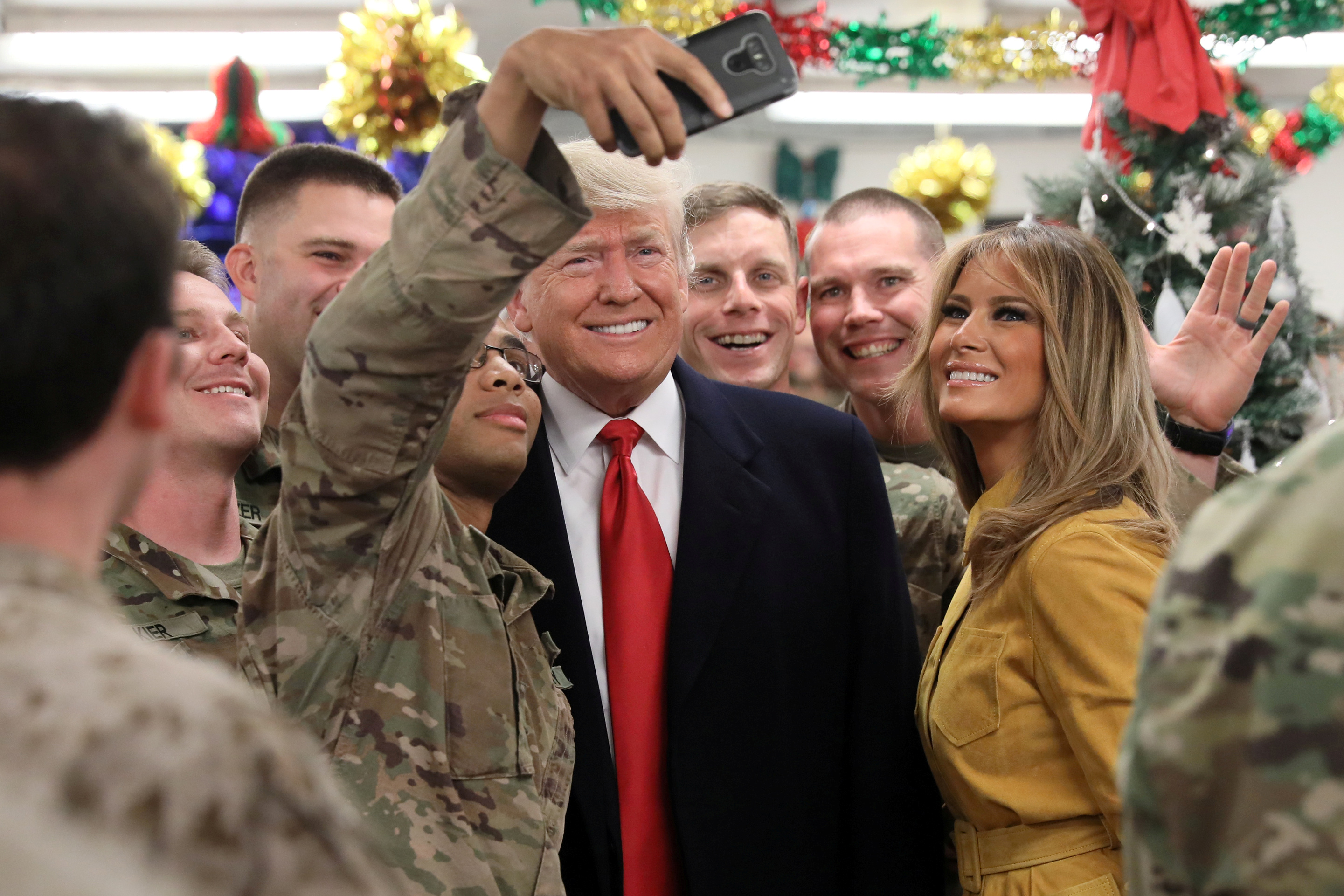 Slide 8 of 11: U.S. President Donald Trump and First Lady Melania Trump greet military personnel at the dining facility during an unannounced visit to Al Asad Air Base, Iraq December 26, 2018. REUTERS/Jonathan Ernst     TPX IMAGES OF THE DAY - RC1CCDFD93E0