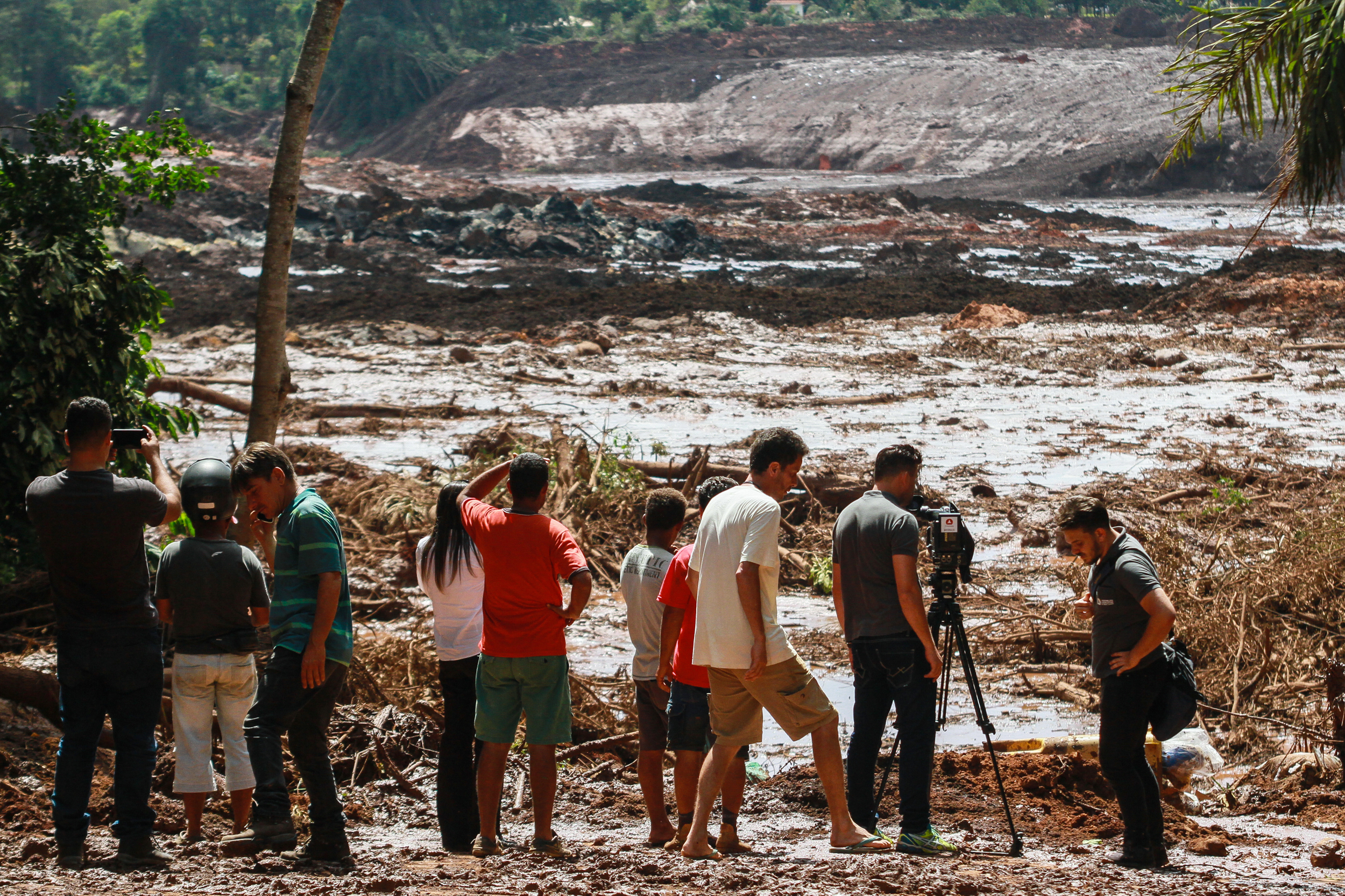 Slide 20 de 75: 25 January 2019, Brazil, Brumadinho: People observe the mud masses after the break of a dam at the FeijÃ£o iron ore mine. Photo: Rodney Costa/dpa (Photo by Rodney Costa/picture alliance via Getty Images)