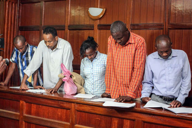 Slide 1 of 28: (L-R) Osman Ibrahim, Guleid Abdihakim, Gladys Kaari Justus, Oliver Muthee and Joel Nganga, six suspects arraigned in court in connection with an Islamist attack on a Nairobi hotel complex that left 21 dead, stand in the courthouse of Nairobi, on January 18, 2019. - A magistrate granted a request from the prosecution to detain the four men and one woman for 30 days while investigations continue. The suspects are accused of 'possible involvement' in the almost 20-hour siege of the DusitD2 hotel and office complex by a suicide bomber and four gunmen who were killed by security forces, a court document said. (Photo by STRINGER / AFP)        (Photo credit should read STRINGER/AFP/Getty Images)