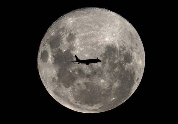 Slide 4 de 31: An Embraer 190-100IGW plane (registration LV-CKZ) of Aerolineas Argentinas, on a regular flight from Buenos Aires to the Argentine city of Bahia Blanca, passes in front of the 'Supermoon' as seen from Buenos Aires on February 19, 2019. (Photo by Alejandro PAGNI / AFP)        (Photo credit should read ALEJANDRO PAGNI/AFP/Getty Images)