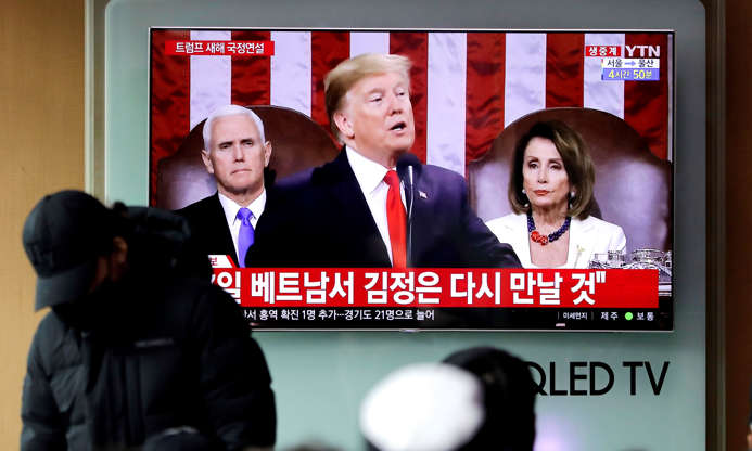 Slide 6 of 32: People watch a TV screen showing a live broadcast of U.S. President Donald Trump delivering his State of the Union address at the Seoul Railway Station in Seoul, South Korea, Wednesday, Feb. 6, 2019. The letters read  Will meet Kim Jong Un in Vietnam. (AP Photo/Lee Jin-man)