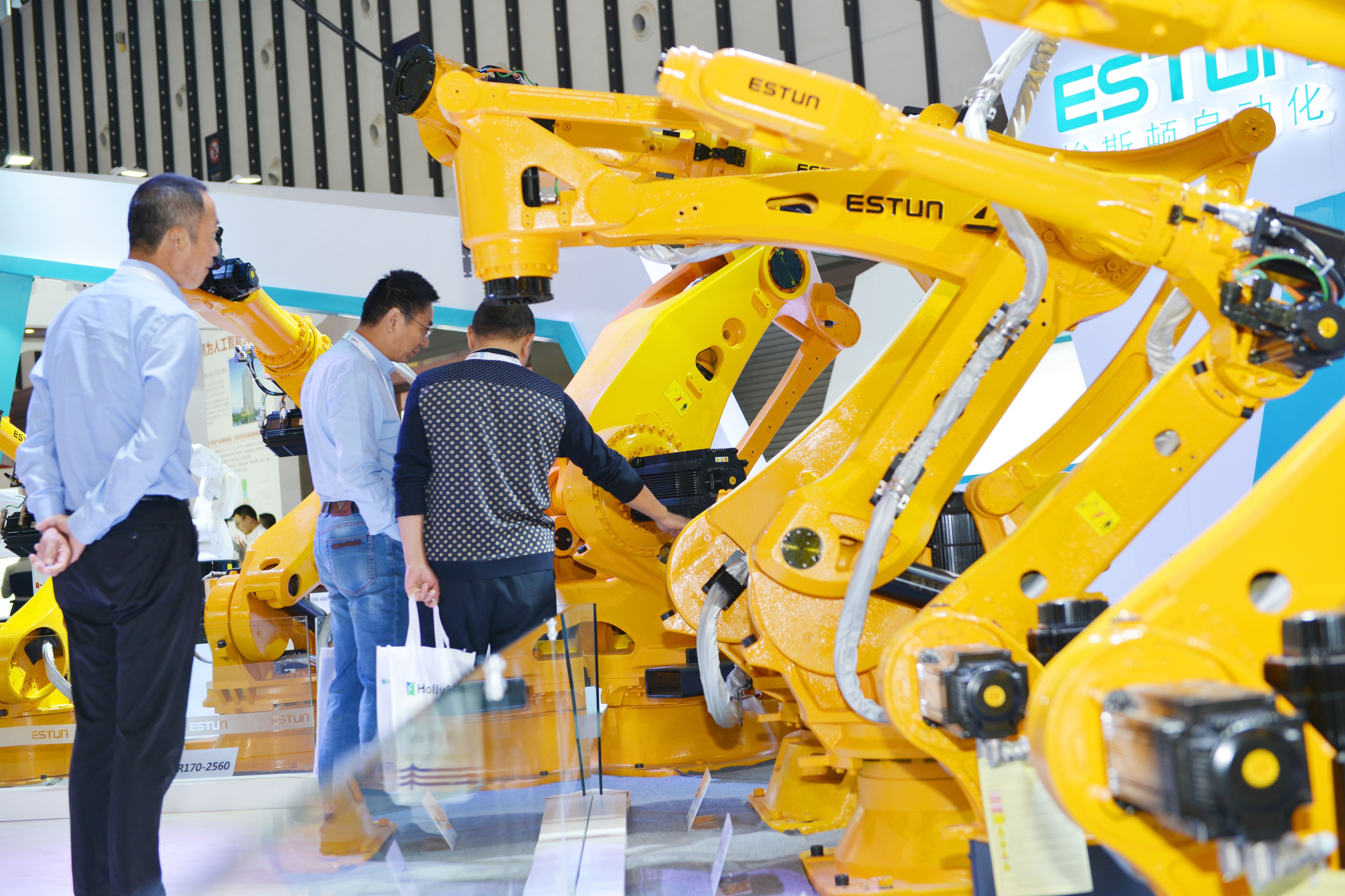 NANJING, CHINA - OCTOBER 11: People look at Estun industrial robots during the 2018 World Intelligent Manufacturing Summit at the Nanjing International Expo Center on October 11, 2018 in Nanjing, Jiangsu Province of China. The 2018 World Intelligent Manufacturing Summit with the theme of 'empowering the future through intelligent manufacturing' is held on October 11-13 in Nanjing. (Photo by VCG/VCG via Getty Images)