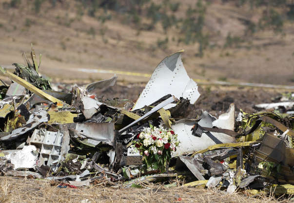 Slide 11 of 48: A bouquet of flowers is placed in front of a pile of debris at the scene of the Ethiopian Airlines Flight 302 crash on March 13, 2019 in Ejere, Ethiopia. All 157 passengers and crew perished after the Ethiopian Airlines Boeing 737 Max 8 Flight came down six minutes after taking off from Bole Airport.