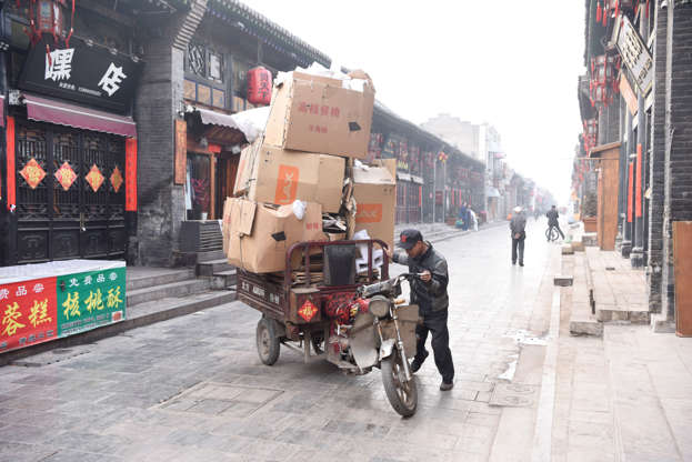 Slide 26 de 45: PINGYAO, CHINA - APRIL 7:  A man is seen about to ride his overloaded motorbike in the streets of the old city on April 7, 2017 in Pingyao, China (Ian Hitchcock/Getty Images)