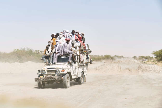 Slide 25 de 45: TOPSHOT - Chadian travels on a overloaded truck across the desert on the way to Bol, in southern Chad, on November 9, 2018. - These old and overcharged all-terrain vehicles represent the only way to carry people and merchandise to the remote areas close to the Lake Chad. (Photo by MICHELE CATTANI / AFP)        (Photo credit should read MICHELE CATTANI/AFP/Getty Images)