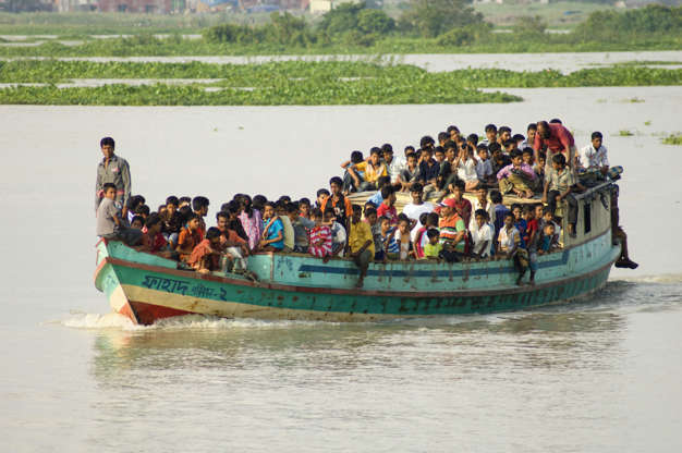 Slide 31 de 45: Bangladesh, Dhaka Division, Keraniganj Upazila, Overcrowded boat travelling down a tributary river.