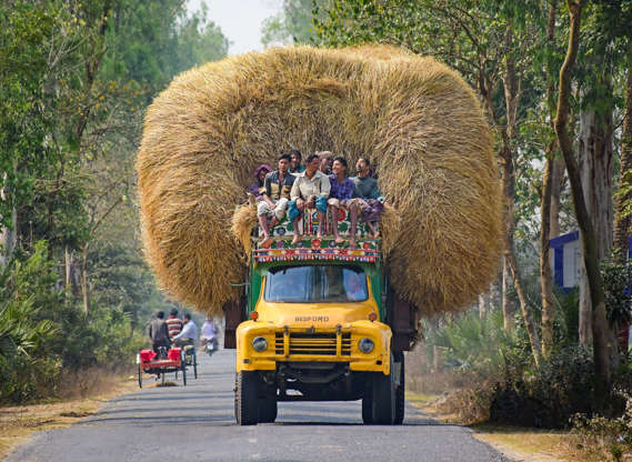 Slide 38 de 45: People ride on trucks ovelroaded with hay
