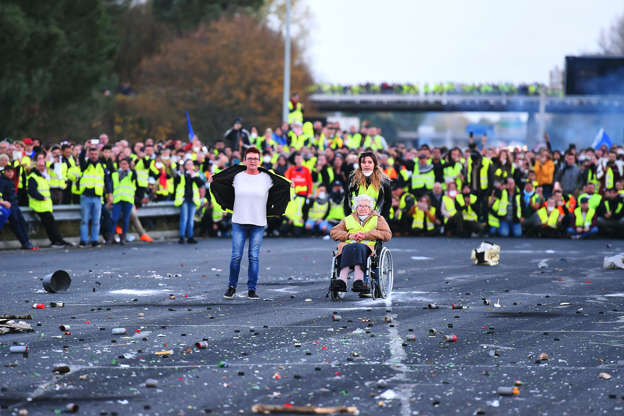 Slide 2 of 34: TOPSHOT-FRANCE-POLITICS-ECONOMY-FUEL-DEMOTOPSHOT - Protesters face riot police as they block the A10 motorway in Virsac, near Bordeaux, southwestern France, on November 18, 2018, on a second day of demonstrations after a nationwide people's initiated day of protests called 'yellow vest' (Gilets Jaunes in French) movement against high fuel prices, which has mushroomed into a widespread protest against stagnant spending power under French President. - More than 400 people were hurt, 14 seriously, in a day and night of 'yellow vest' protests over rising fuel price hikes around France that claimed one life, the Interior minister said on November 18. The injury toll, more than double the last tally provided the eve, what the minister described as a 'restive' night in 87 locations around the country where protesters had blocked roads to express their anger at a series of hikes in petrol tax. (Photo by NICOLAS TUCAT / AFP)        (Photo credit should read NICOLAS TUCAT/AFP/Getty Images)