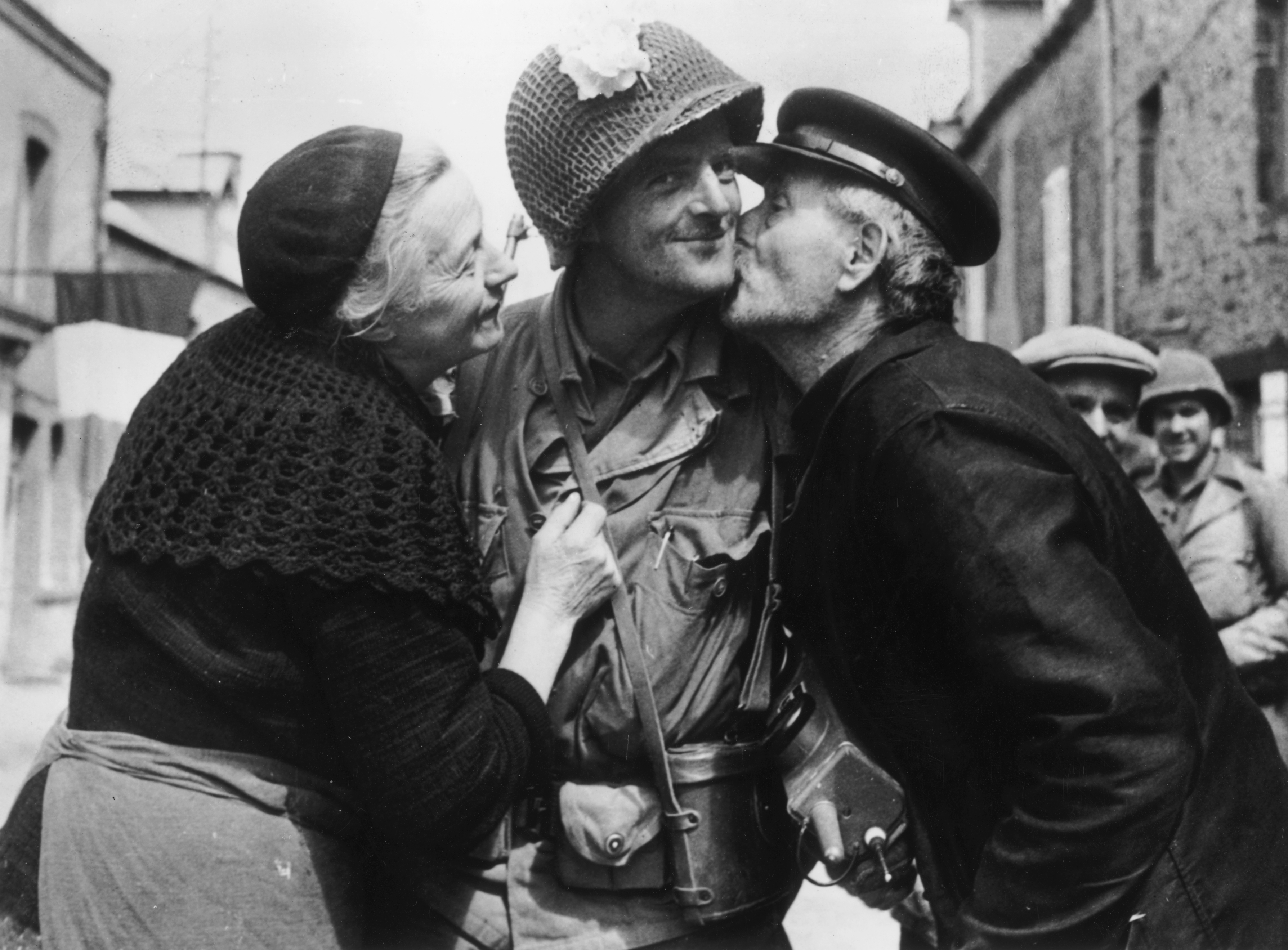 Slide 9 of 50: An American soldier is given a warm welcome by an elderly French couple, after the town of St Saveur was liberated. (Photo by Keystone/Getty Images)