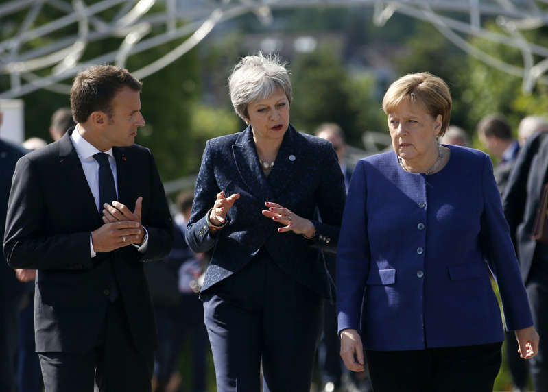 FILE - In this Thursday, May 17, 2018 file photo German Chancellor Angela Merkel, right, speaks with French President Emmanuel Macron, left, and British Prime Minister Theresa May after meeting at a hotel on the sidelines of the EU-Western Balkans summit in Sofia, Bulgaria. (AP Photo/Darko Vojinovic, File)