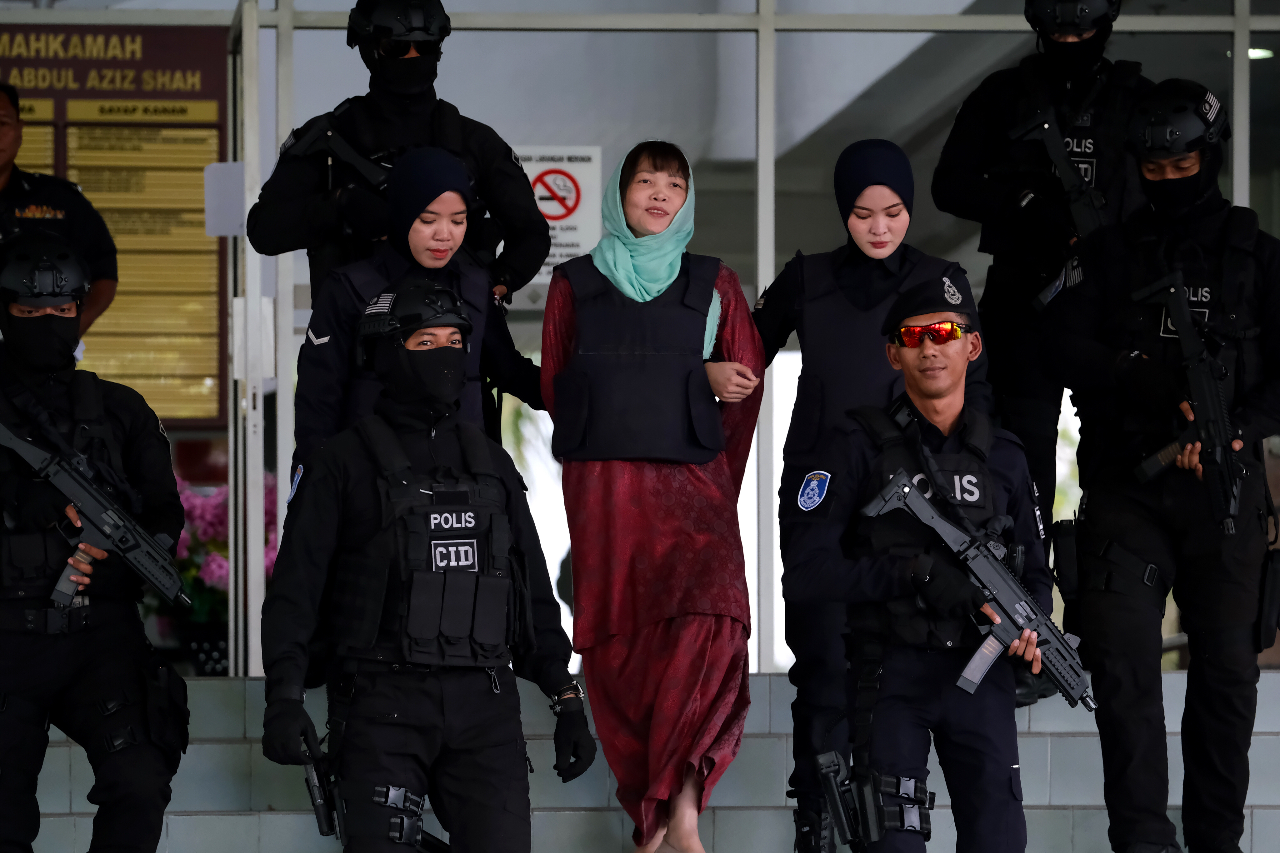 SHAH ALAM, MALAYSIA - APRIL 1  : Vietnamese Doan Thi Huong, as she smiles escorted by police after a court session for her trial at the Shah Alam High Court for murder case of Kim Jong Nam, North Korean leader Kim Jong Un's brother, on April 1, 2019 in Shah Alam, Malaysia. Malaysian prosecutors dropped a murder charge after she pleaded guilty to a lesser charge of causing harm using dangerous means. Down Thi Huong from Vietnam had been accused of killing Kim Jong Nam by smearing VX nerve agent on his face at the Kuala Lumpur International Airport 2 (klia2) in 2017. (Photo by Mohd Samsul Mohd Said/Getty Images)