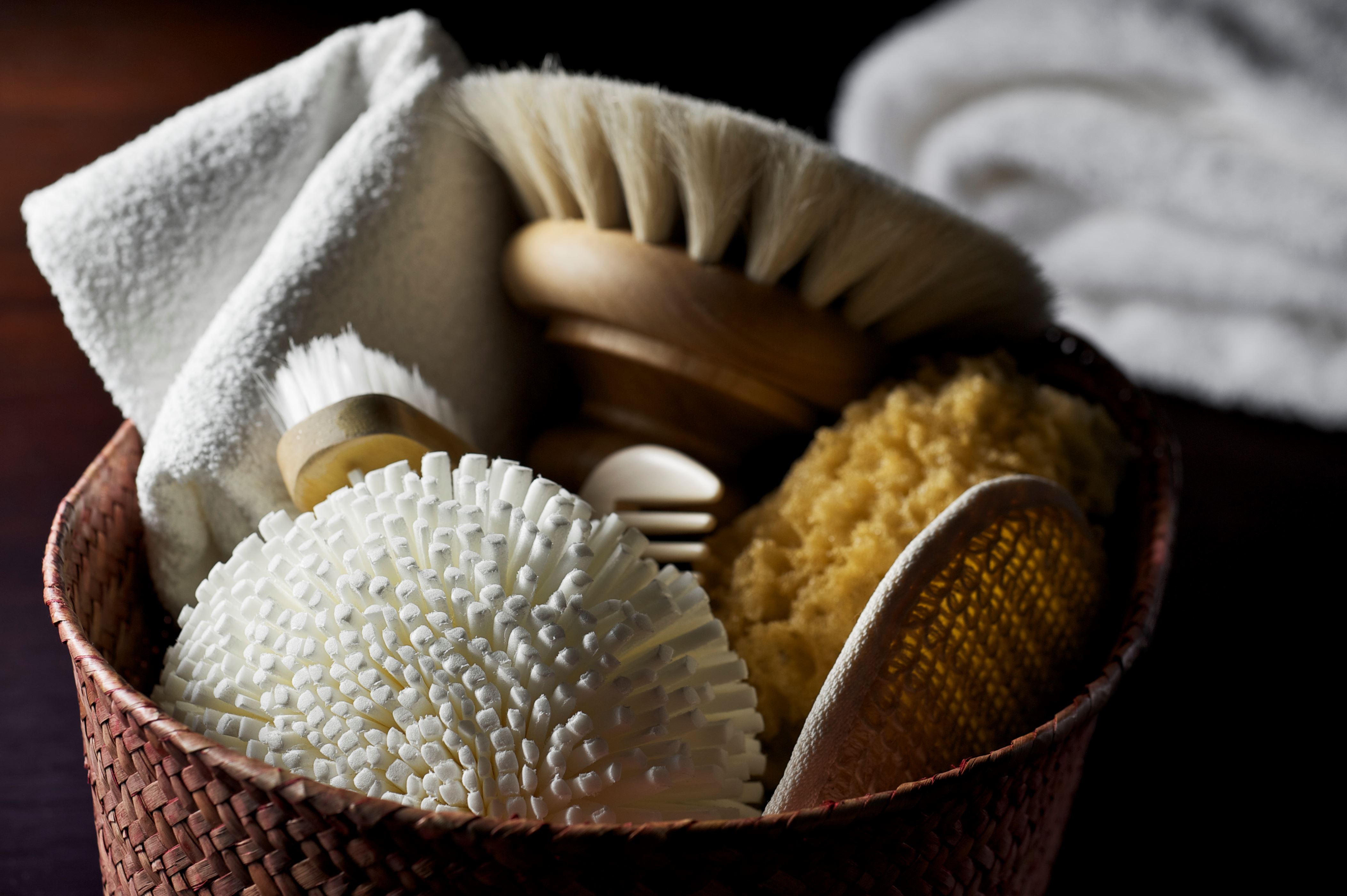 'Variety of natural body care goods, including sponges, wooden body polishing brushes and wooden comb in a low key, relaxing environment.  Shallow DOF.'