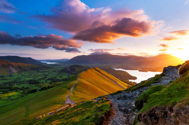 Слайд 32 из 34: Sunrise from Catbells fell in the Cumbrian mountains; golden light at sunrise and a moody vivid sky, makes for a atmospheric feel to this Lake District landscape image, taken on Catbells Fell near Keswick, looking North towards Skiddaw massive. Keswick, Lake District, Cumbria. UK, Europe.
