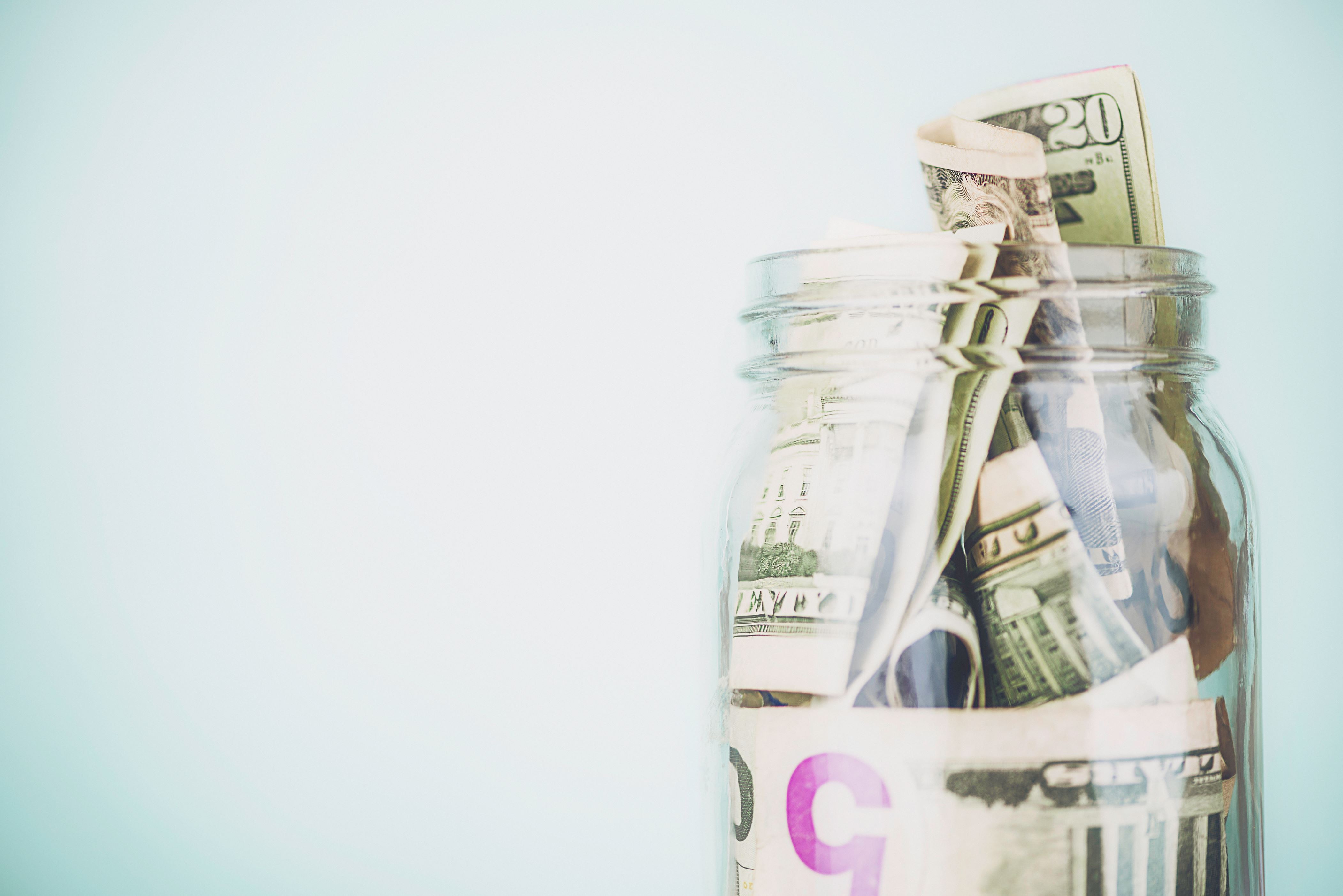 Donation jar overflowing with American money. Fundraising, Savings, Wealth Concepts.