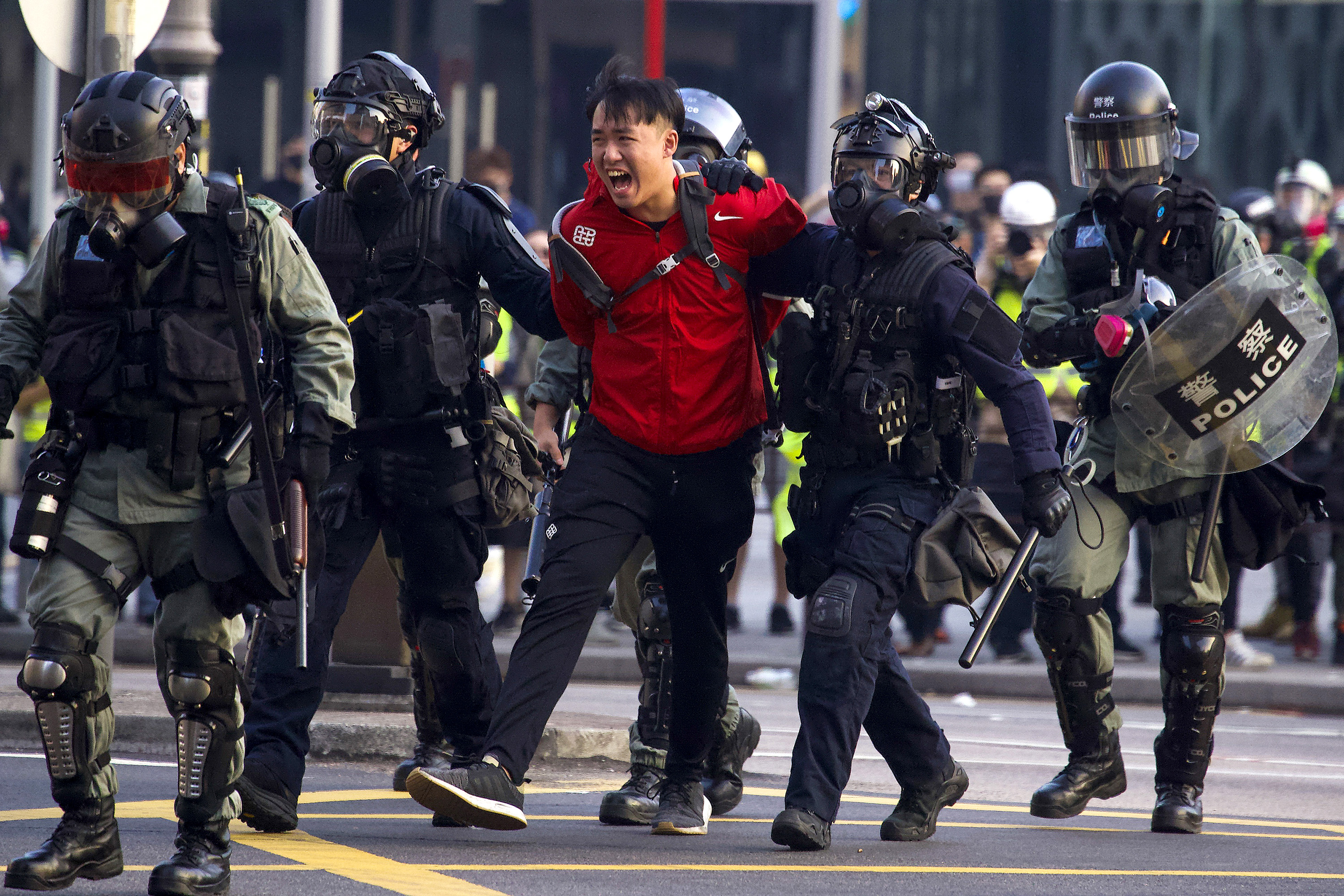 Slide 1 of 50: A pro-democracy protester shouts after being detained by policemen during a rally in Hong Kong, Sunday, Dec. 1, 2019. A huge crowd took to the streets of Hong Kong on Sunday, some driven back by tear gas, to demand more democracy and an investigation into the use of force to crack down on the six-month-long anti-government demonstrations. (AP Photo/Ng Han Guan)