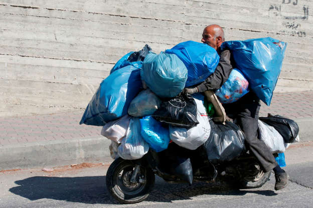 Slide 10 de 45: Adnan al-Zaatari, a Palestinian garbage collector, rides a motorcycle loaded with bags of recyclable waste for sale in the West Bank town of Hebron on October 2, 2019. (Photo by HAZEM BADER / AFP) (Photo by HAZEM BADER/AFP via Getty Images)