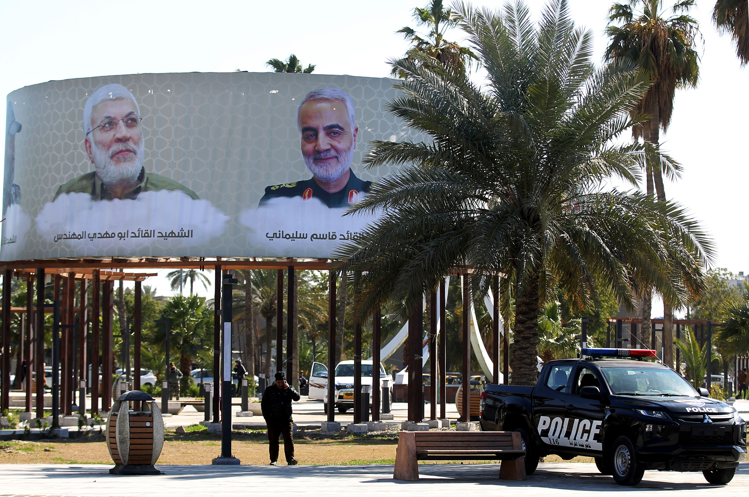 Slide 3 of 48: This picture taken on February 10, 2020 in the Iraqi capital Baghdad's district of Karrada shows an Iraqi police vehicle parked beneath mourning billboards on display, depicting top Iranian general Qasem Soleimani and Iraqi paramilitary commander Abu Mahdi al-Muhandis, who were killed in a US drone strike near Baghdad airport that rocked the region. - February 11 marks the passing of 40 days since Soleimani and al-Muhandis were killed. The passing for 40 days is an important milestone of mourning for several faiths, including Shiite Muslims. (Photo by AHMAD AL-RUBAYE / AFP) (Photo by AHMAD AL-RUBAYE/AFP via Getty Images)