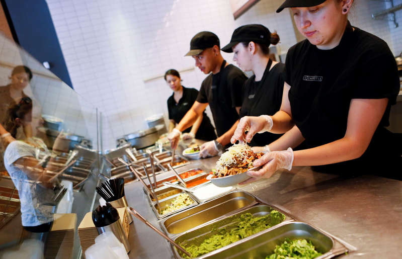 Employees prepare orders for customers at a Chipotle Mexican Grill Inc. restaurant in Hollywood, California on Tuesday, July 16, 2013.