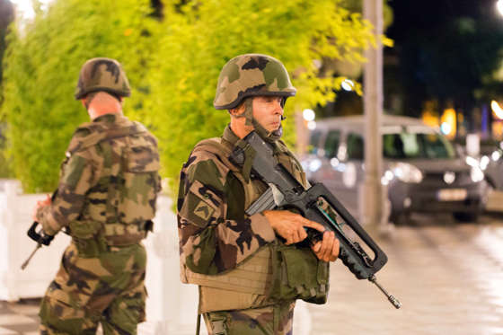 French soldiers stand guard by the sealed off area of an attack after a truck drove on to the sidewalk and plowed through a crowd of revelers who'd gathered to watch the fireworks in the French resort city of Nice, southern France, Friday, July 15, 2016.