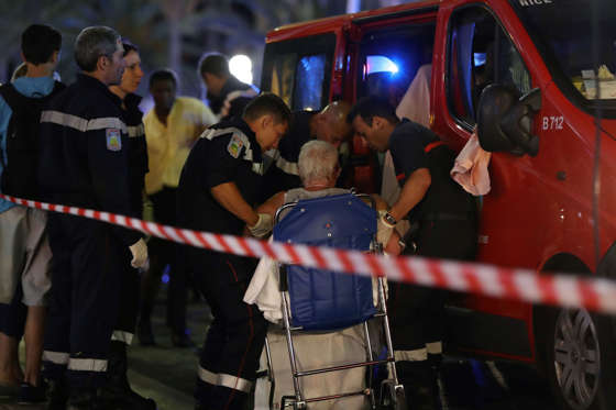 Rescue workers help an injured woman to get in a ambulance on July 15, 2016, after a truck drove into a crowd watching a fireworks display in the French Riviera town of Nice.
A truck ploughed into a crowd in the French resort of Nice on July 14, leaving 