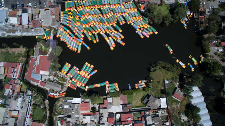 ÎÎ¹Î±ÏÎ¬Î½ÎµÎ¹Î± 10 Î±ÏÏ 100: Aerial view taken with a drone of moored 'trajineras' -traditional flat-bottomed river boat- at Xochimilco natural reserve in Mexico City on April 1, 2016. Xochimilco canals are one of the places most visited by local and foreign tourists, to go along th