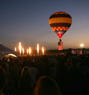 Flames are seen from the burners of several hot air gondolas, without their ball...