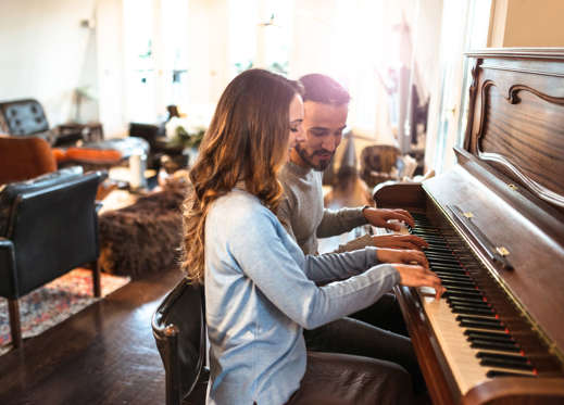 Diapositiva 19 de 39: Young couple playing the piano together.
