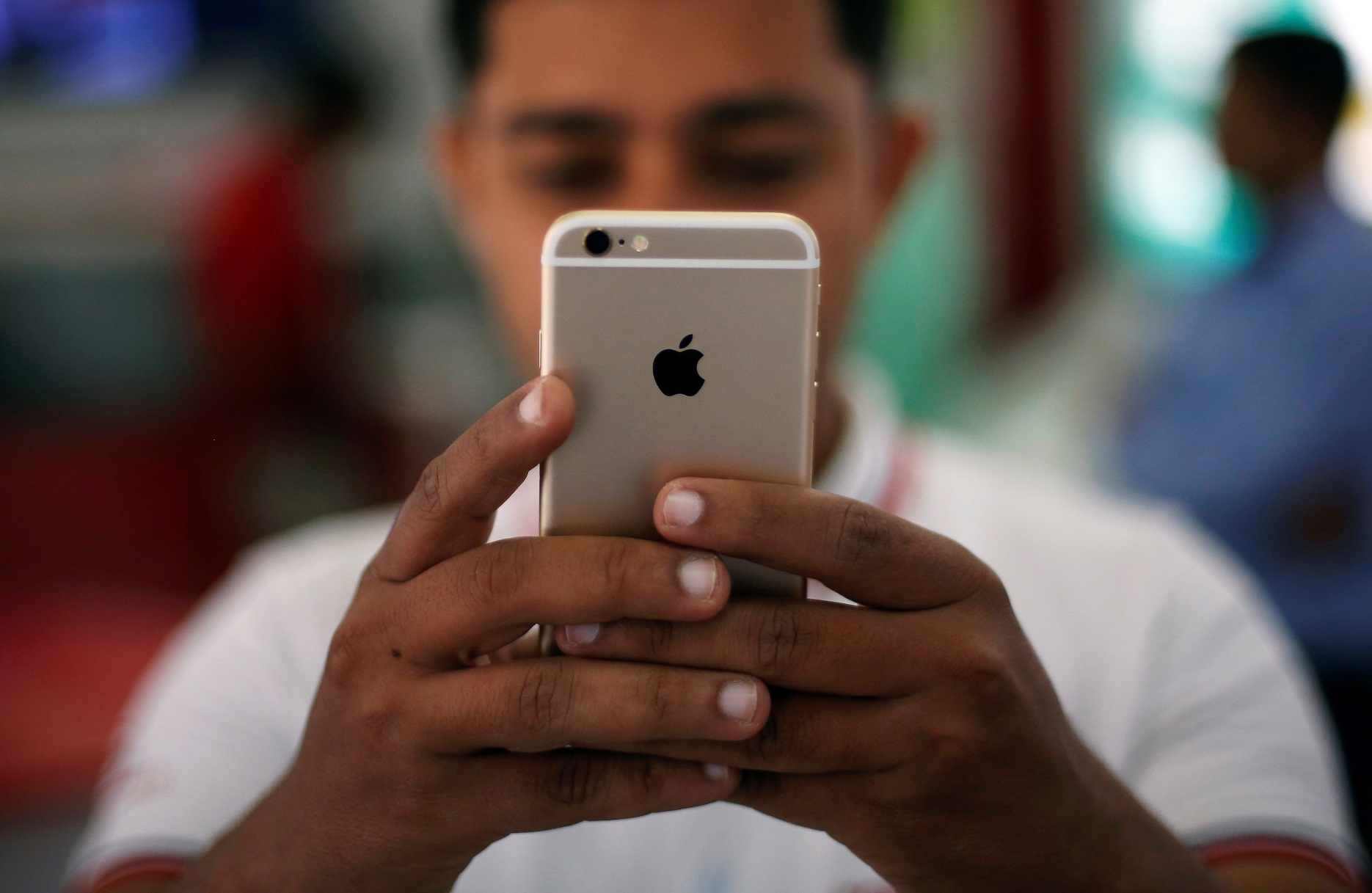 A salesman checks a customer's iPhone at a mobile phone store in New Delhi, India, July 27, 2016.