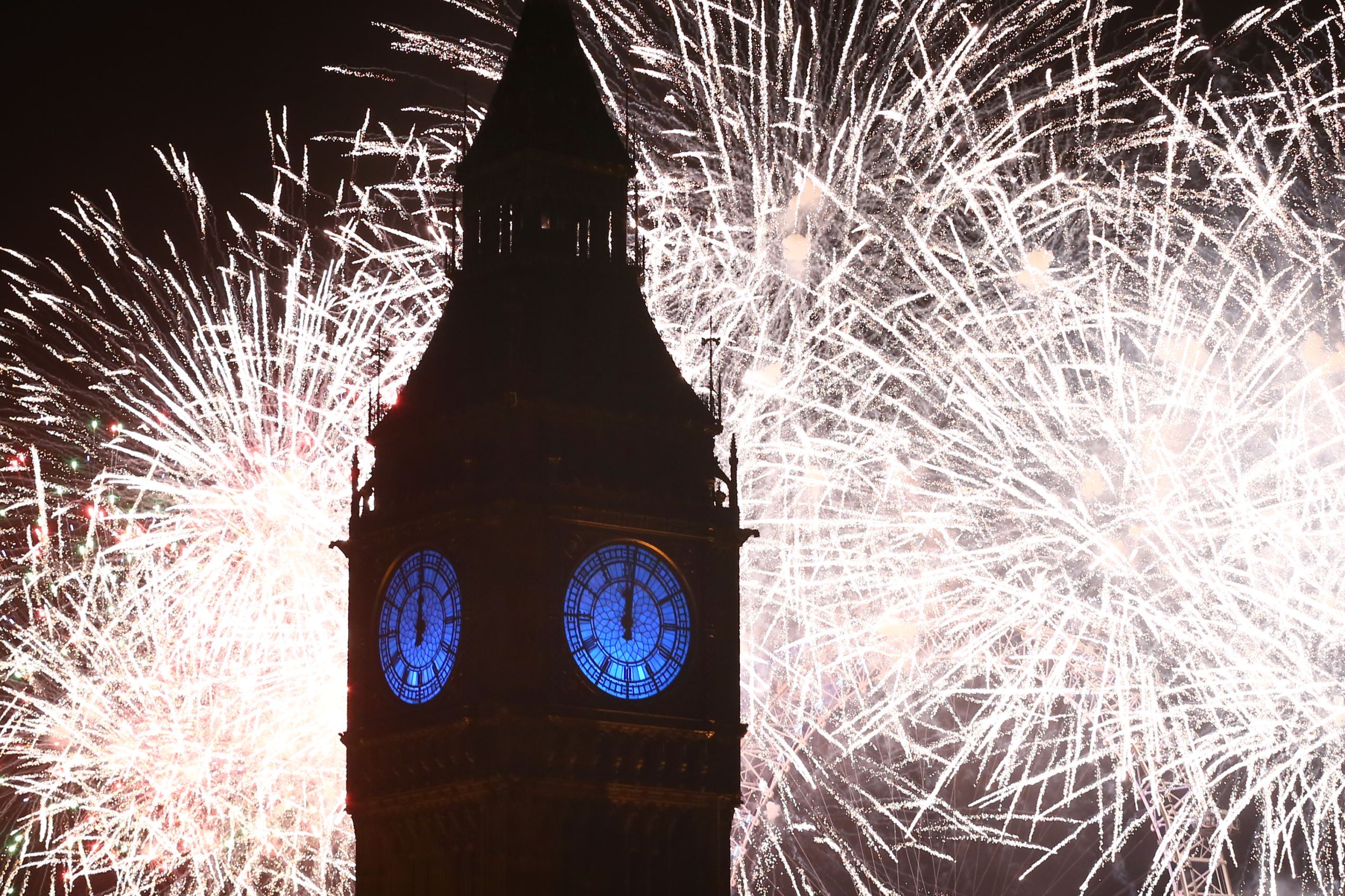 LONDON, ENGLAND - JANUARY 01: Fireworks light up the London skyline and Big Ben just after midnight on January 01, 2016 in London, England. Thousands of people have bought tickets to stand on the banks of the River Thames near Parliament to celebrate the start of 2016. (Photo by Carl Court/Getty Images)